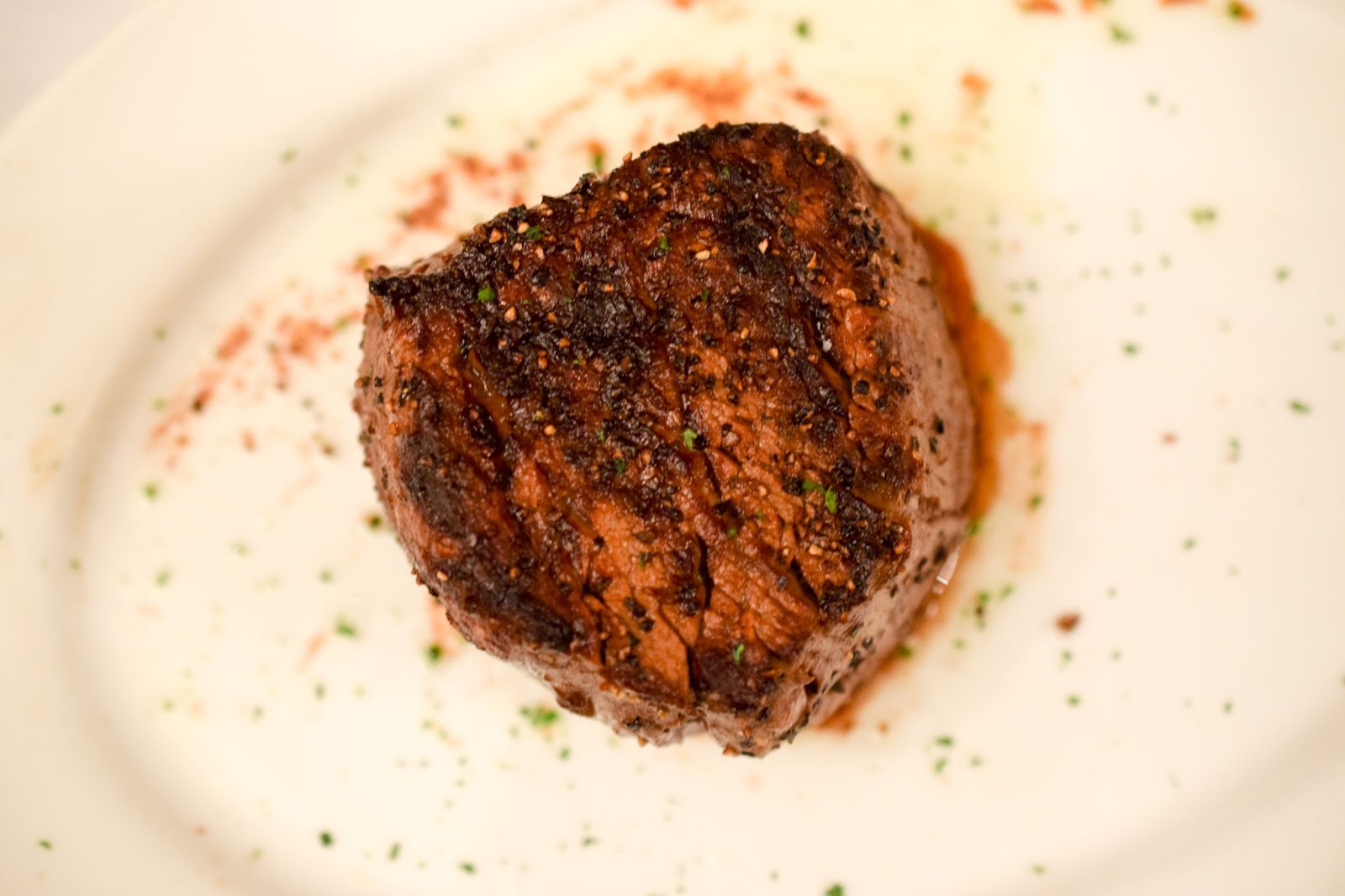 a cut of filet mignon on a plate shown from above