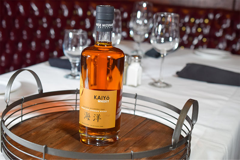 a bottle of Kaiyo whiskey on a wooden tray at Christner’s steakhouse