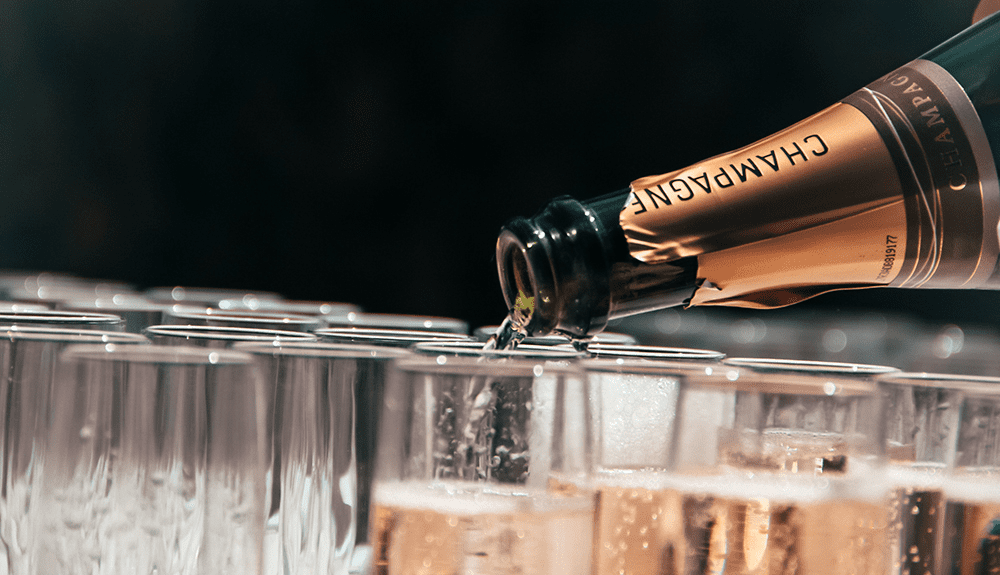 a champagne bottle being poured into glasses
